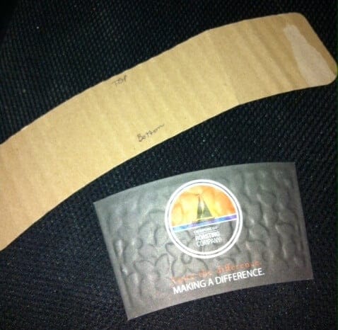 A cardboard coffee sleeve being used as a template for our DIY coffee sleeve template.
