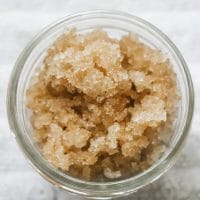 A close up of homemade sugar scrub in a quarter pint mason jar with the lid off.