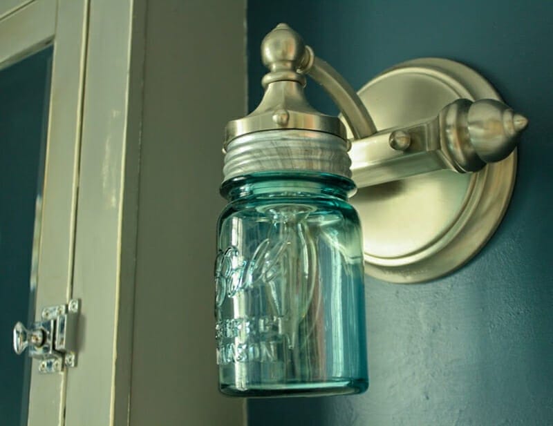 A blue mason jar as the globe on a silver wall sconce. 