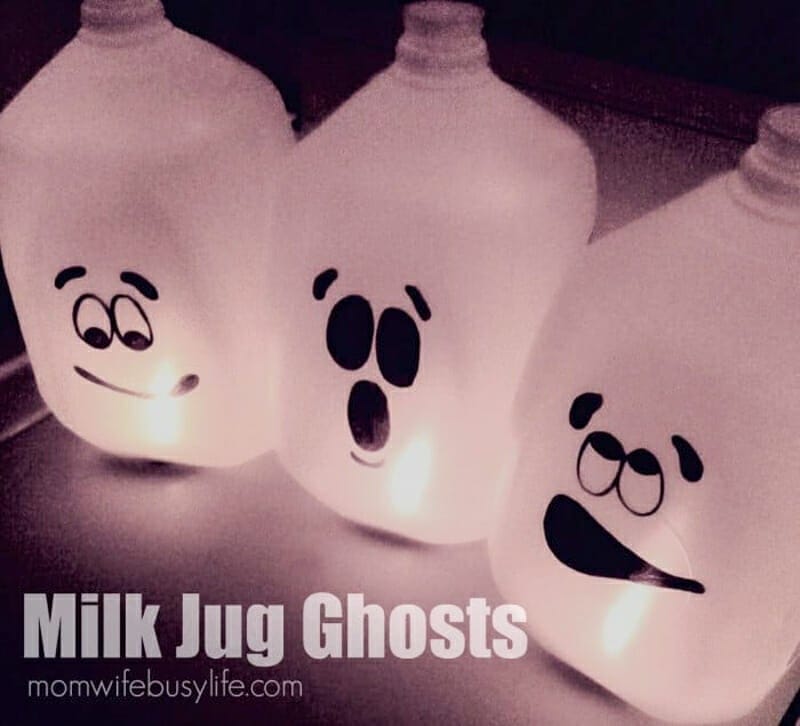 Ghost faces drawn onto milk jugs with sharpies and light up with fake candles.