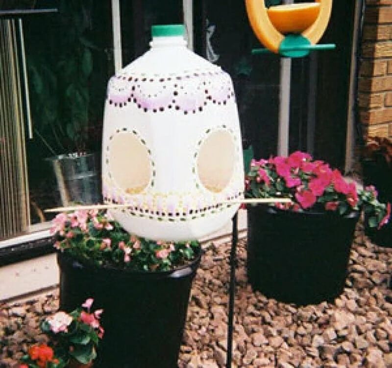 A decoratively painted milk jug turned into a bird feeder.