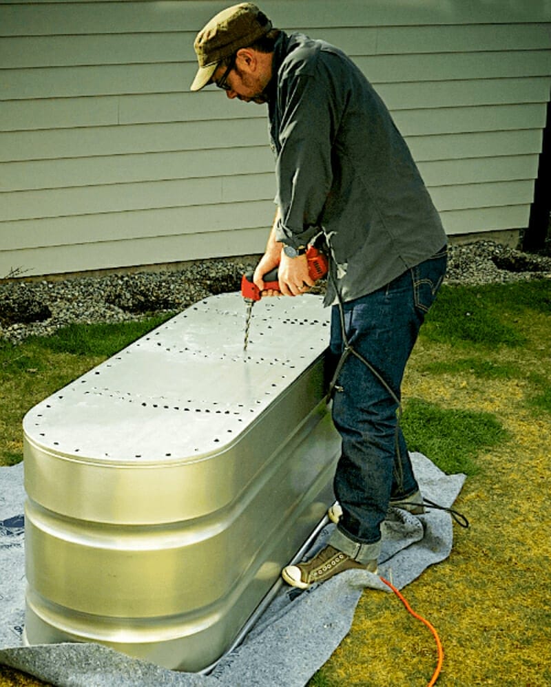 Drilling holes with a power drill into the galvanized planter.
