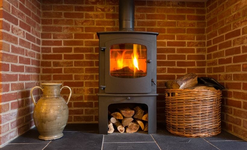A new, modernized wood stove placed in a retired fireplace hearth.